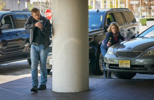 Kenny (Kellan Lutz) et Jackie (Amy Carlson) avancent tous deux arme à la main.